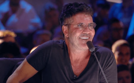 Simon Cowell in a black t-shirt passing comments as a judge.